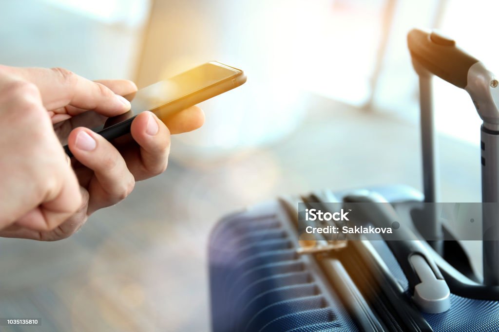 Passengers waiting at the airport/ Passenger using mobile phone